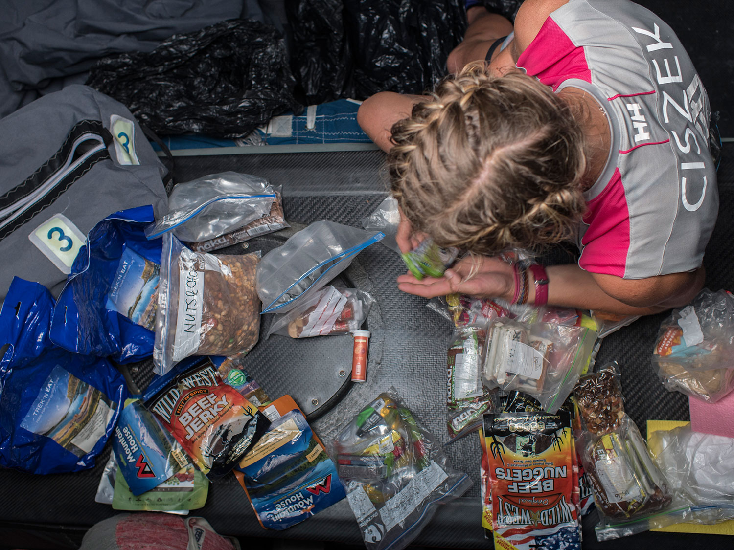 Sophie Ciszek organizes and consolidates a few food bags. The boat carries only freeze dried foods